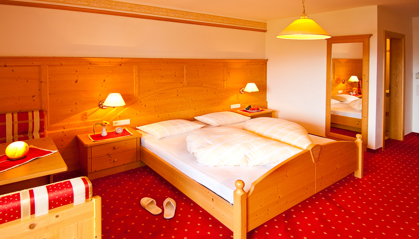 una camera accogliente con letto matrimoniale nell' Hotel Tannenhof a Riscone