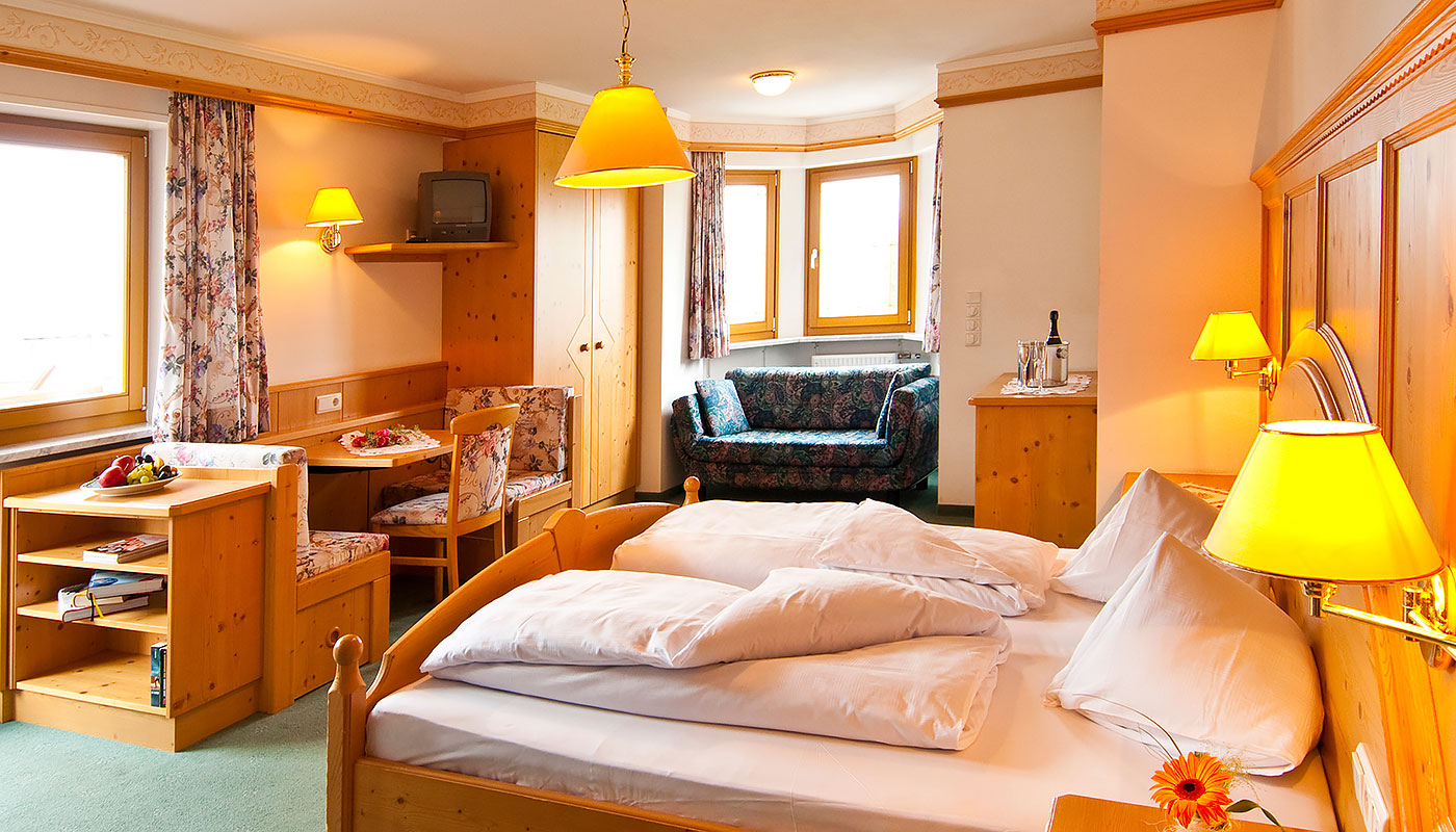 una confortevole camera matrimoniale con mobili in legno dell' Hotel Tannenhof