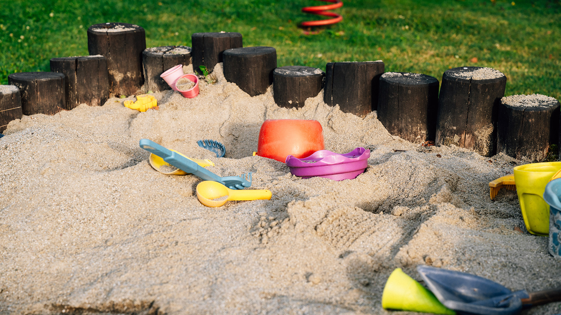 Sabbiera colorata con giocattoli nel giardino dell'Hotel Tannenhof, ideale per vacanze in famiglia a Plan de Corones.
