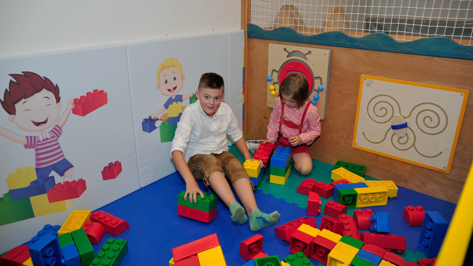 Due bambini giocano allegramente nell'angolo giochi colorato del Familienhotel Tannenhof am Kronplatz.