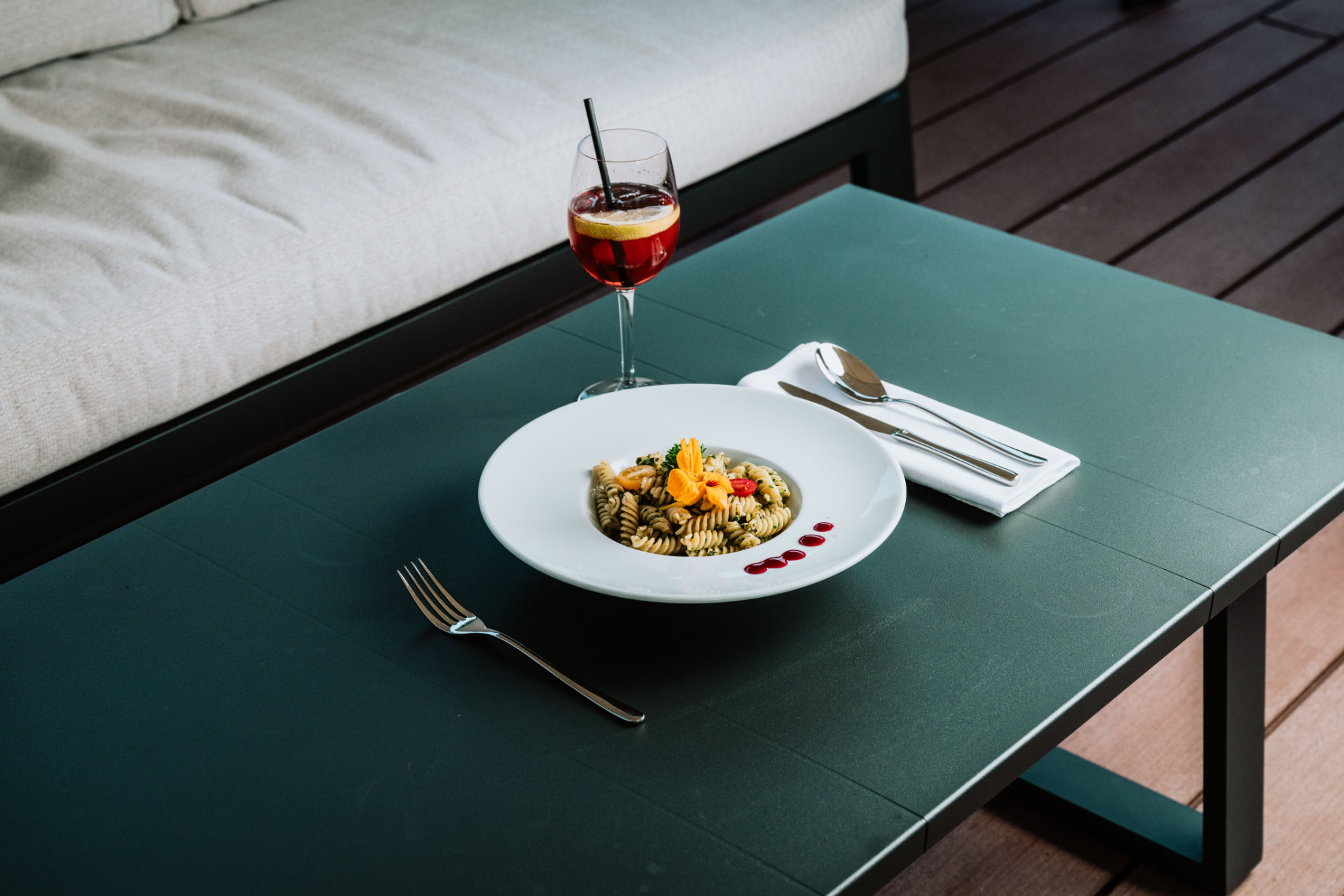 Un piatto di pasta appetitoso con spinaci e un cocktail su un tavolo nell'Hotel Tannenhof.
